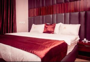a bedroom with a large bed with red and white pillows at HOTEL D RITZ in Aba Adi