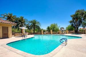 a swimming pool in a resort with palm trees at Charming patio home w/ community pool, WFH setups, 10 min walk to Old Town! in Scottsdale