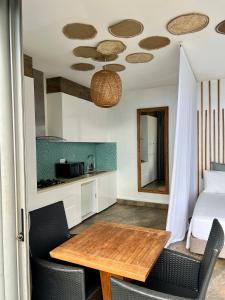 uma cozinha com uma mesa e cadeiras e uma cama em Suite by the Pool em Faaa