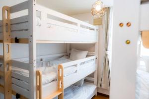 a bunk bed room with white bunk beds at 2024年3月新規OP/最大18名/駐車場2台無料/大画面ゲーム＆映画鑑賞/札幌中心部まで車で10分 in Tsukisappu