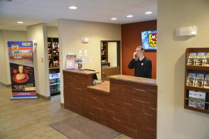 a man talking on a cell phone at a counter in a store at My Place Hotel-Rock Springs, WY in Rock Springs