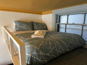 ein Bett mit einer grünen Bettdecke und einem Fenster in der Unterkunft Your Home with Patio Historic Halifax, Apt#3 in Halifax