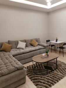 un soggiorno con divano e tavolo di شقق الياسمين a Medina