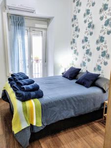 a bedroom with a large bed with blue and yellow blankets at ALOJAMIENTO LANZA en el CORAZÓN DE SEVILLA in Seville