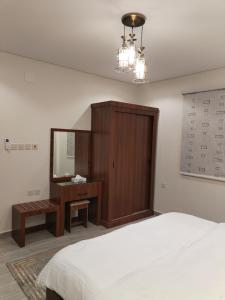 a bedroom with a bed and a desk and a mirror at شقق الياسمين in Medina