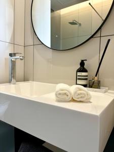 ein weißes Badezimmer mit zwei Handtüchern auf einem Waschbecken in der Unterkunft The Capital in Sandton-Luxury aparthotel in Johannesburg
