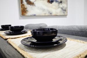two black cups and plates on a table at Stylish Retreat with King Bed, Long Stays, WEM, Disney+ in Edmonton