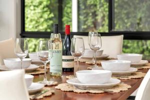 a table with wine bottles and plates and wine glasses at Entire home in Mount Barker in Mount Barker