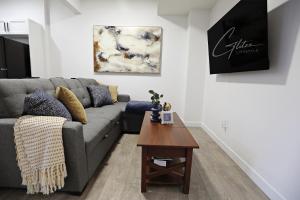 a living room with a gray couch and a table at Stylish Retreat with King Bed, Long Stays, WEM, Disney+ in Edmonton