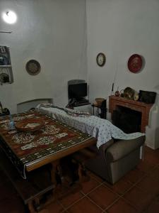 ein Wohnzimmer mit einem Tisch und einem Klavier in der Unterkunft Giacometti Alentejo Peroguarda His last Desire in Peroguarda