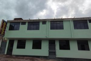 a white building with black barred windows on it at Hospedaje LOS OLIVOS in Ayacucho
