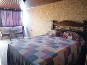 um quarto com uma cama, uma mesa e cadeiras em La Mansión de las Cascadas em Chimaltenango