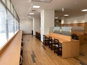 una sala de conferencias con mesas y sillas de madera en Hotel Alpha-One Tottori, en Tottori