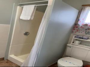 a small bathroom with a shower and a toilet at Echo Motel in Old Orchard Beach