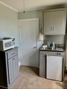 una pequeña cocina con fregadero y microondas en Echo Motel en Old Orchard Beach