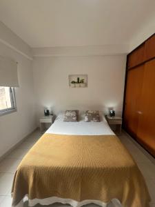 sypialnia z dużym łóżkiem i dwoma stołami w obiekcie Departamento Premium Céntrico w mieście Salta