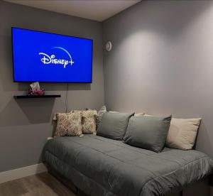 a living room with a couch with a tv on the wall at Life house loft in Sooke