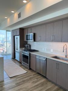 a kitchen with stainless steel appliances and wooden cabinets at San Diego Convention Center Padres Ocean Views SD Zoo in San Diego