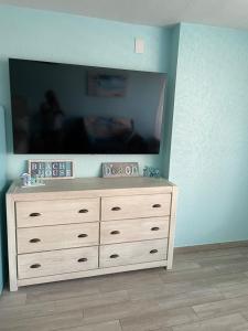 TV en la parte superior de un tocador en una habitación en Ocean Views Retreat . Enjoy the Ocean View from your balcony, en Daytona Beach