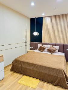 1 dormitorio con 1 cama grande con manta marrón en TMS Apartments Quy Nhơn, en Quy Nhon