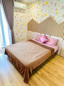 Un dormitorio con una cama con almohadas rosas. en TMS Apartments Quy Nhơn, en Quy Nhon