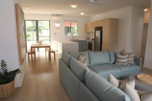 a living room with a blue couch and a kitchen at Coolum Beach Resort in Coolum Beach