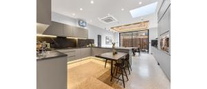 Luxury Abode: 5-Bed Haven Ideal for Big Groups! في لندن: مطبخ مع طاولة وغرفة طعام