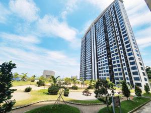 a tall building with a park in front of it at Jesselton Quay Kota Kinabalu City Centre by LW Suites in Kota Kinabalu