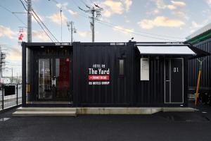 a black building with a sign in front of it at HOTEL R9 The Yard 松阪 in Matsuzaka