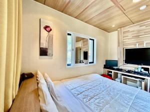 - une chambre avec un lit, un bureau et une télévision dans l'établissement Ocean hotel the Luxe, à Geoje