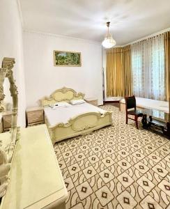 a bedroom with a bed and a desk and a chair at Гостиница Алишер in Dushanbe