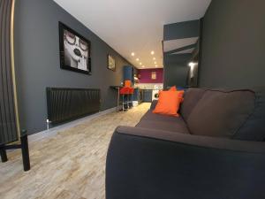 sala de estar con sofá gris y almohadas de color naranja en Liverpool City, Fairfield Duplex Suite, en Liverpool