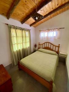 1 dormitorio con cama y techo de madera en DOÑA ROSA CABAÑAS en Luján de Cuyo