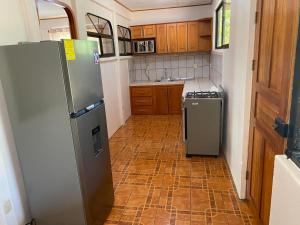 a kitchen with a refrigerator and a tile floor at Casas La Chirincoca in San Isidro de El General