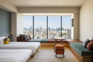 東京にあるOMO5東京五反田 by 星野リゾートのベッド2台と大きな窓が備わるホテルルームです。