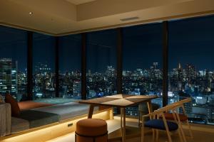 OMO5 Tokyo Gotanda by Hoshino Resorts في طوكيو: غرفة مطلة على المدينة ليلا