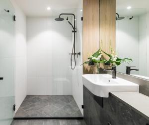 a bathroom with a sink and a shower at Oaks Cairns Hotel in Cairns
