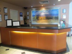 a reception desk with a large painting on the wall at Springwood Tower Apartment Hotel in Springwood