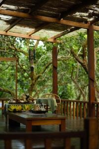 a table on a porch with a wooden pergola at Tini Wood House in Hue