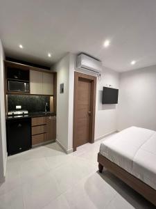 a bedroom with a bed and a kitchen at NOVAPARK FERROVIARIA in Guayaquil