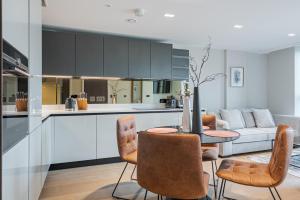 eine Küche und ein Wohnzimmer mit einem Tisch und Stühlen in der Unterkunft Arcadia Residences - Luxury Apartments in Kensington in London