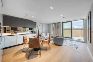 cocina y sala de estar con mesa y sillas en Arcadia Residences - Luxury Apartments in Kensington en Londres