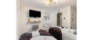 倫敦的住宿－City Nook: Stylish 1-Bedroom with Outdoor Seating，一间卧室设有两张床,墙上配有电视。