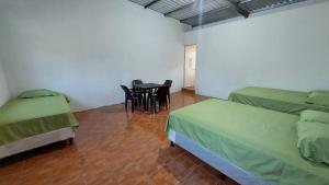 um quarto com duas camas e uma mesa e cadeiras em Villa Santos em Escuintla