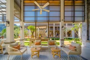 a lobby with chairs and tables and a large window at Bhu Nga Thani Resort & Villas Railay in Railay Beach