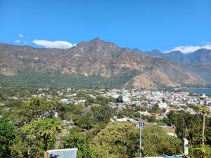 une petite ville en face d'une montagne dans l'établissement Las Cabañas De Mike, à San Juan La Laguna