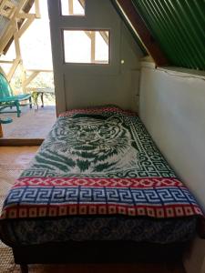 a bed in the corner of a room at Las Cabañas De Mike in San Juan La Laguna