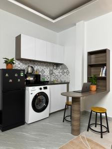 a kitchen with a washing machine and a table with a laptop at Calmette Home in Ho Chi Minh City