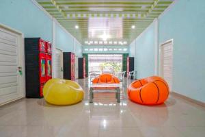 une chambre avec deux grandes balles orange et jaune dans l'établissement Hotel Alam Lestari RedPartner, à Palembang