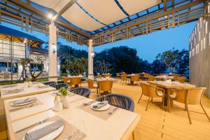 a restaurant with white tables and chairs and a patio at Bhu Nga Thani Resort & Villas Railay in Railay Beach